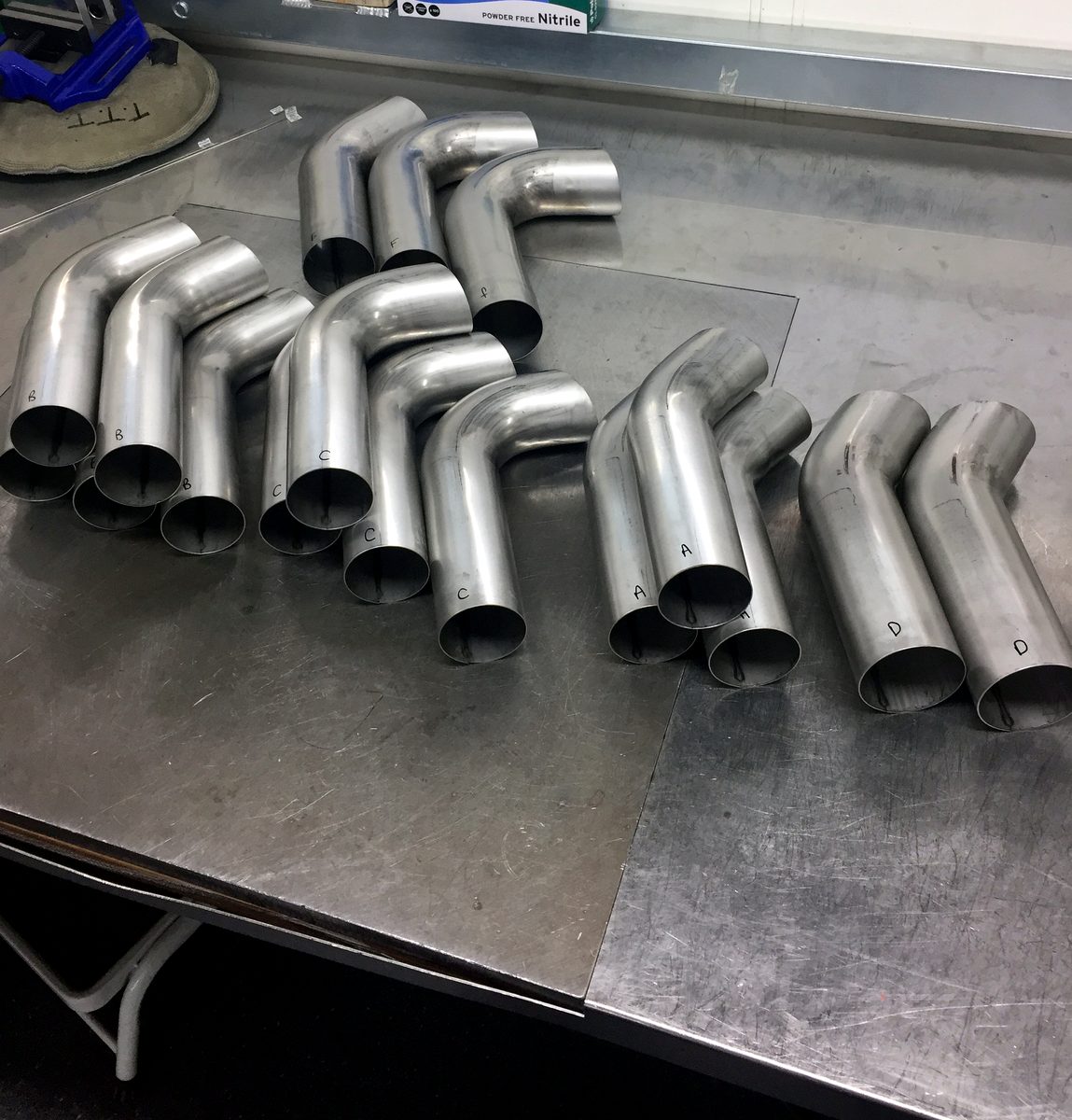 Mandrel-bent pipe sections prepped and laid out for an exhaust build